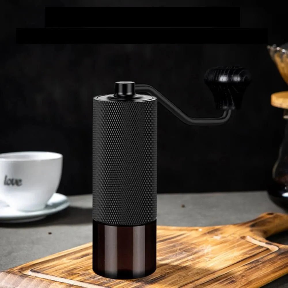 Black manual coffee grinder on a wooden surface with a blurred background